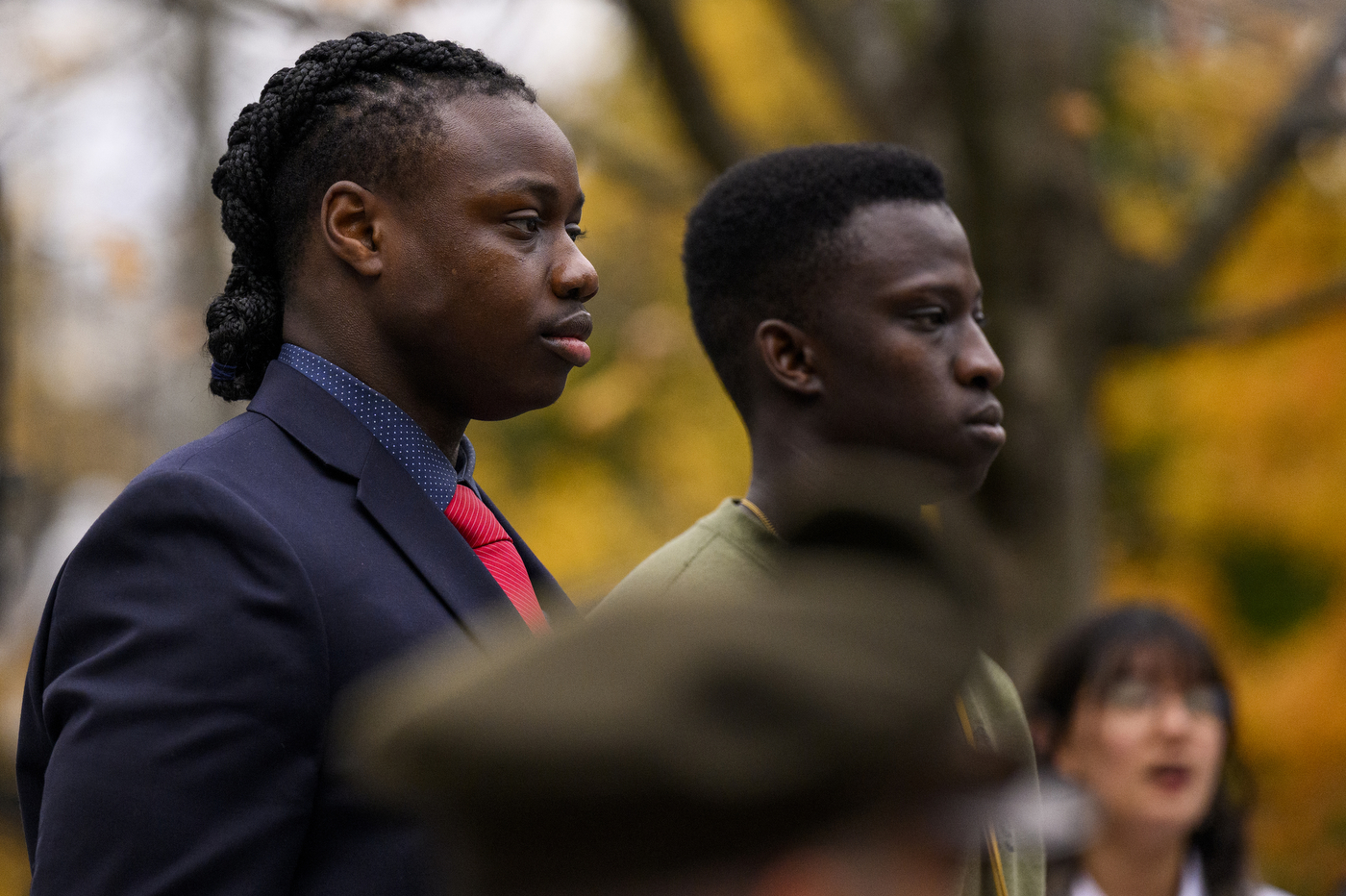 People standing solemnly at the Veterans Day ceremony.