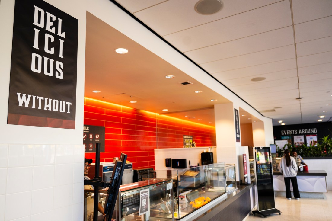 A restaurant at a food court. It has an orange tile background and is backlit orange.