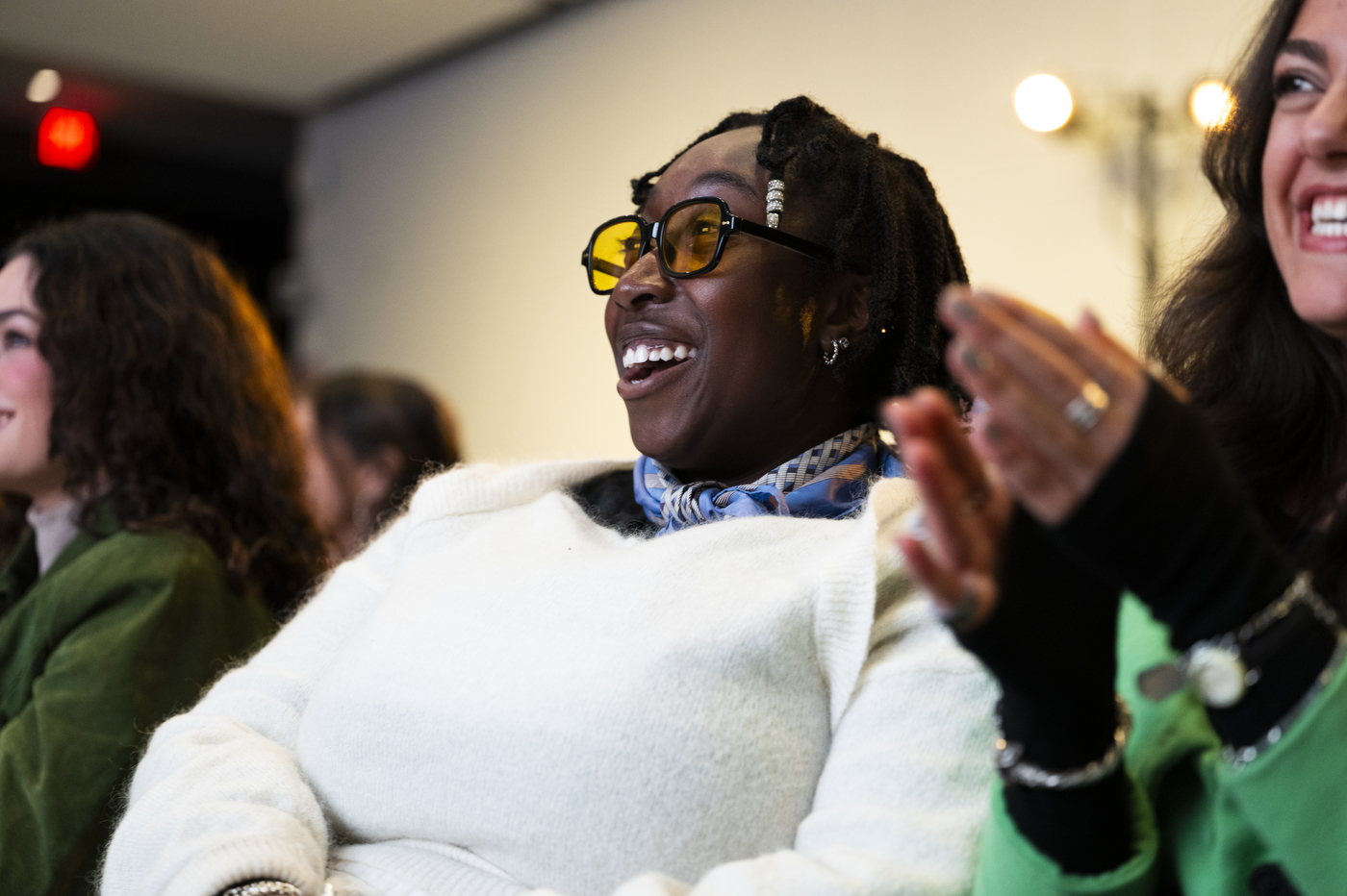 Members of the Northeastern community laughing and clapping while listening to Stuart Weitzman speak.