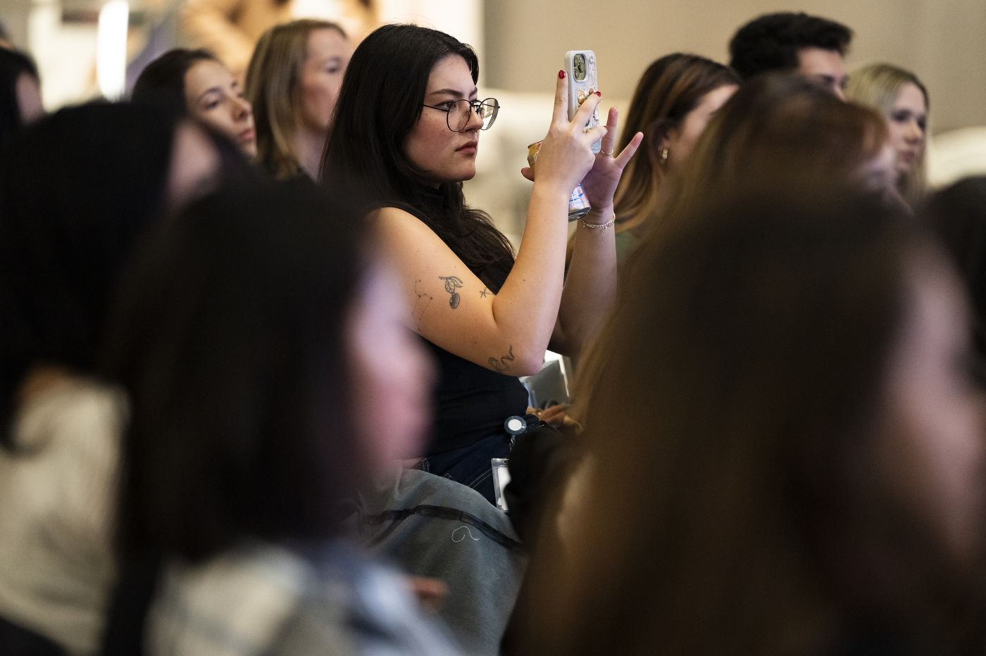 Student taking photographs of Stuart Weitzman on their phone.