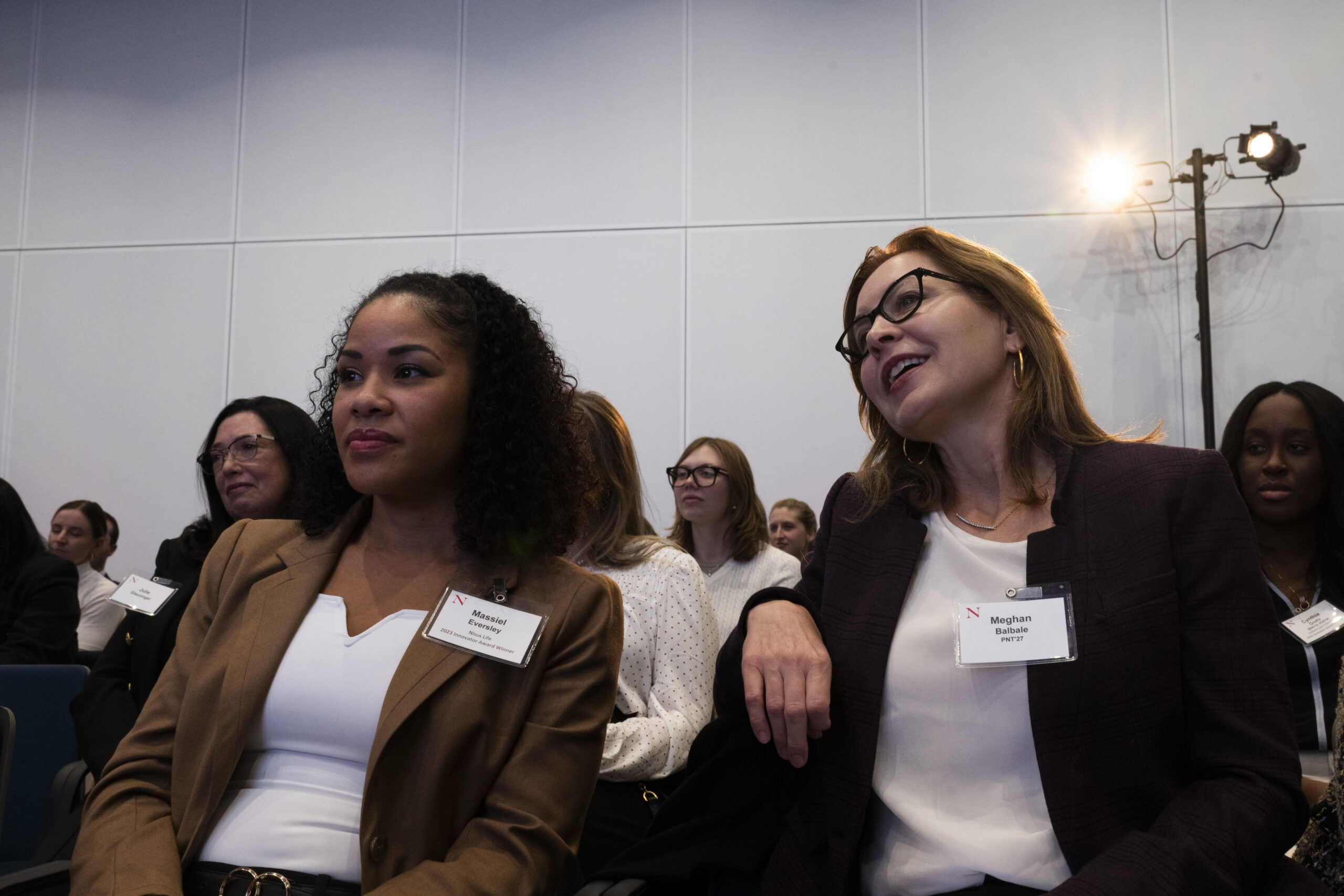 Audience members with name tags listening to a speaker at the Women Who Empower fall summit.