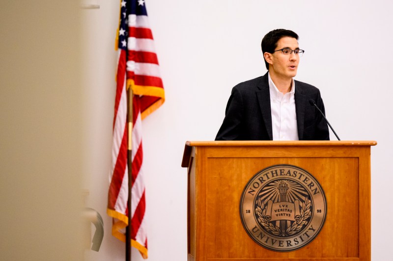 Person speaking into a microphone at the crisis conversation series. 