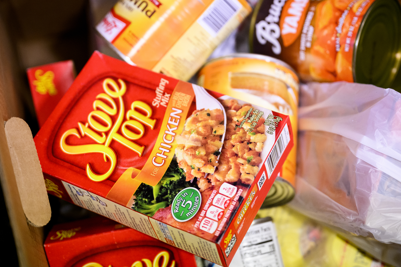 A box of Stove Top Chicken Stuffing Mix on top of cans of pumpkin. 