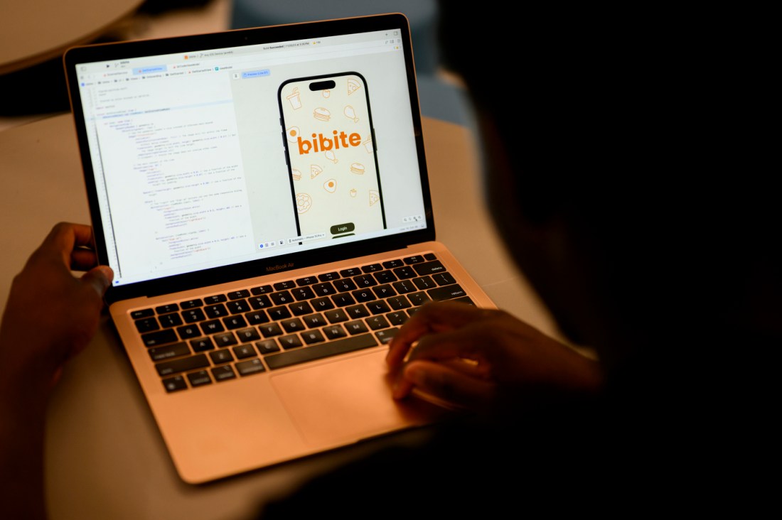 Northeastern student David Alade works on the application for his business, Bibite, writing code on his laptop.