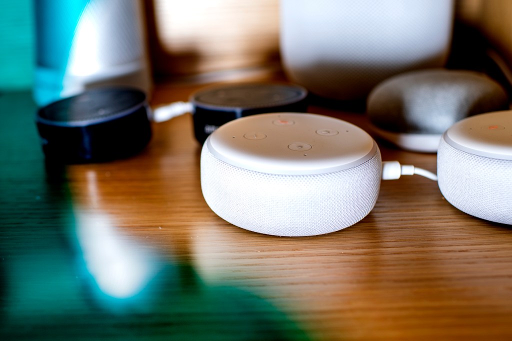 Black and white speakers on top of a wooden table.