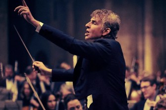 Bradley Cooper as Leonard Bernstein conducting on stage.