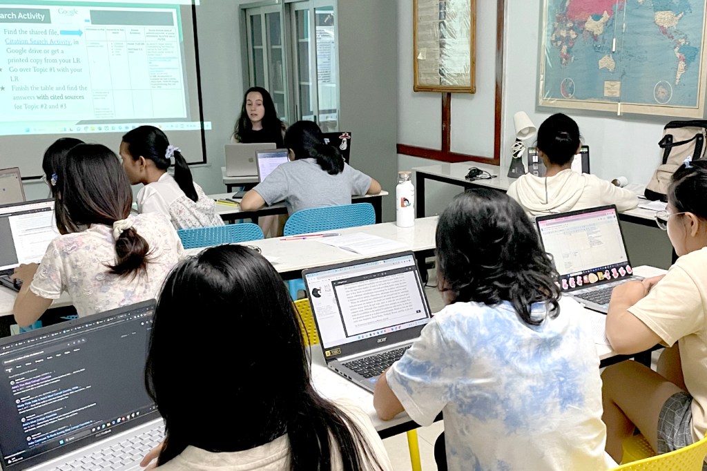 Cambodian women sitting in a classroom working on laptops.