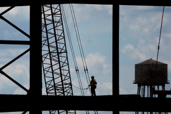 Silhouette of a worker on the framework of a battery plant.