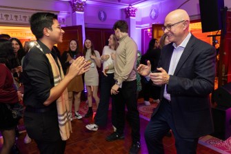 President Aoun dances with a student at Northeastern's Thanksgiving celebration.