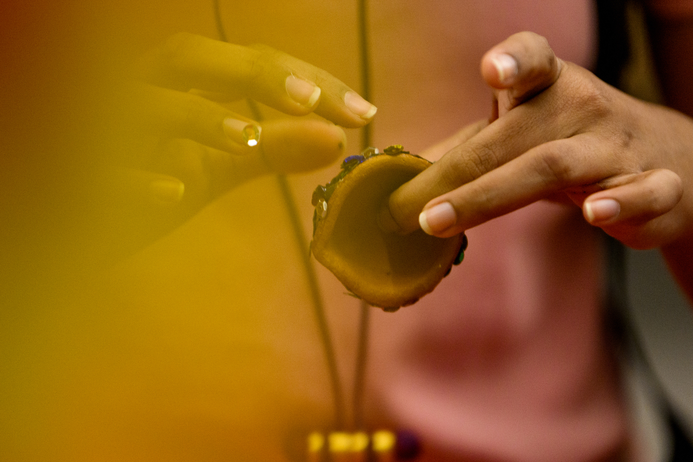 Person holding a candle holder for Diwali.