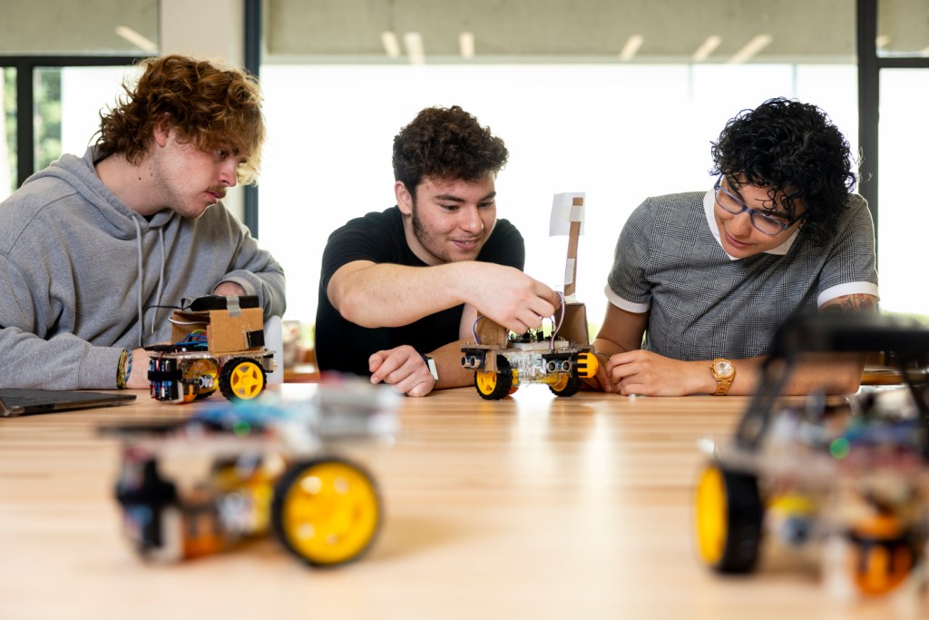 Students working with robots at a table.