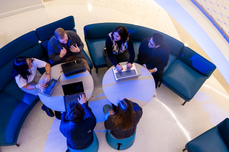 Srirupa Chakraborty and her students sit at lounge couches and tables having a discussion.