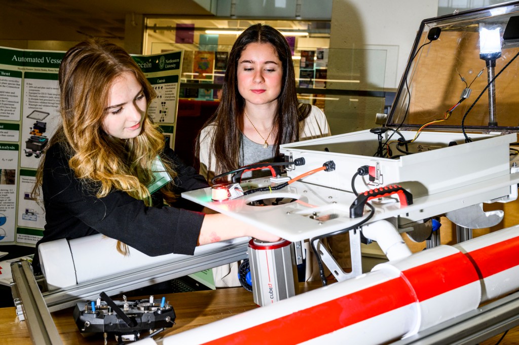 Two students working on robotic boat.