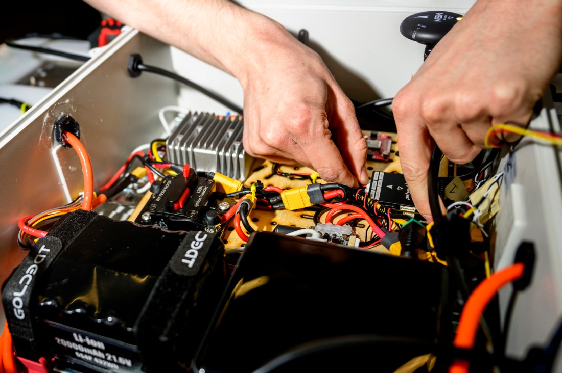 Person working on a robots wiring.