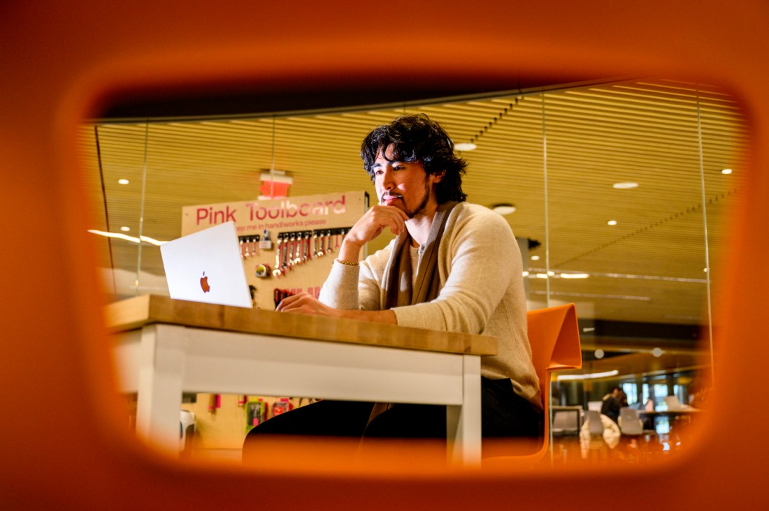 Evan Smith working at a laptop in the EXP building.