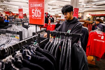 Person looking through the racks of clothing at the Northeastern University book store on the Boston campus.