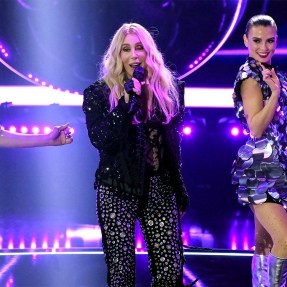 Cher performing on stage in front of two backup dancers.