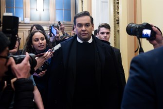 George Santos leaving Congress with photographers taking pictures of him.