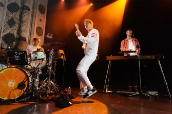 Glass Animals band members playing various instruments on stage.