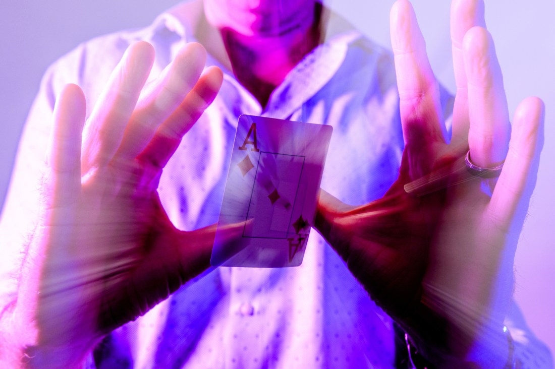 Person doing a card trick with the ace of diamonds.