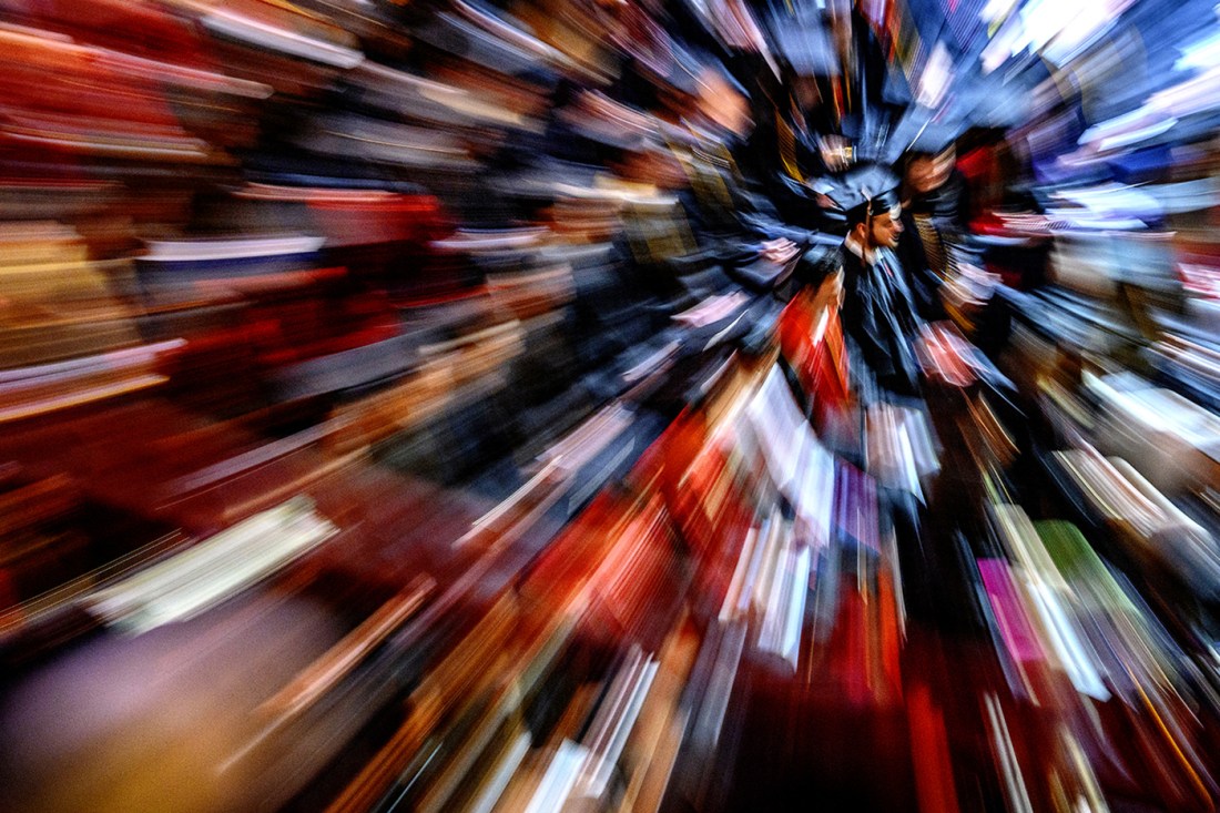 Long exposure photo of a member of the Northeastern community wearing a cap and gown.