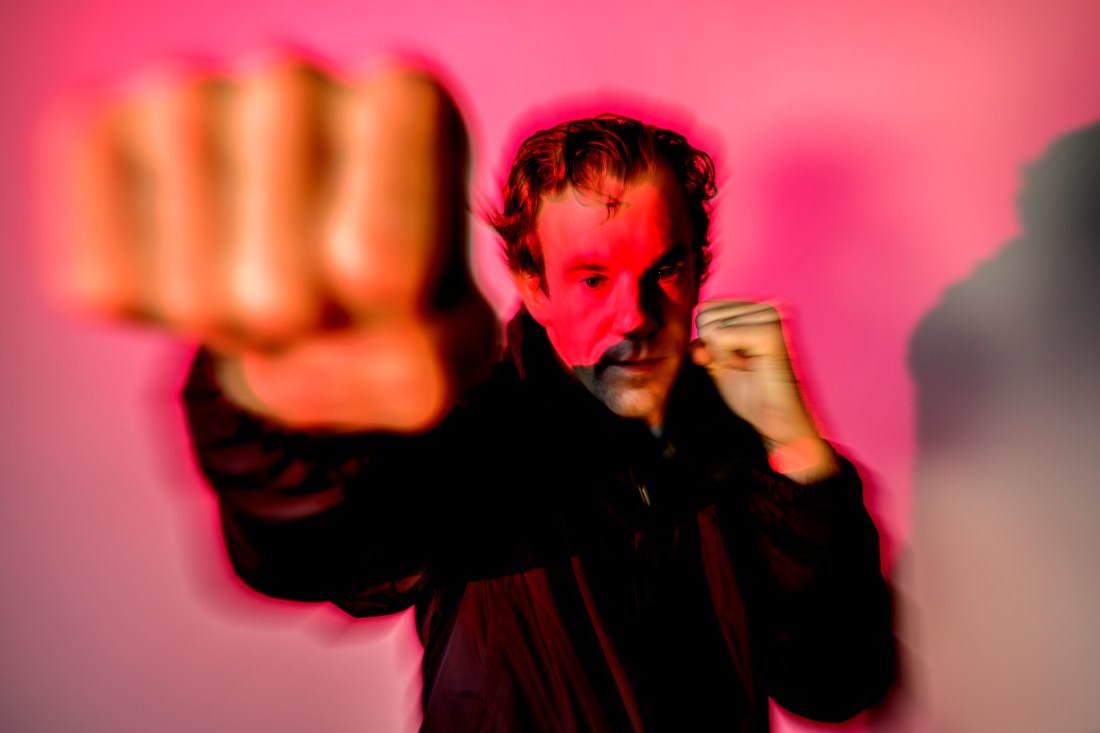 Action shot of a Northeastern community member demonstrating a punch towards the camera.