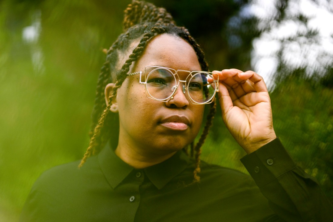Headshot of a Northeastern community member adjusting their glasses. 