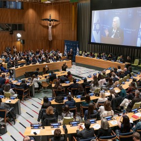 Audience members setting in at an event at the UN Headquarters listening to Senator Kirsten Gillibrand speaking.