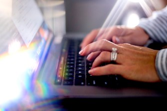 Hands typing on a laptop.