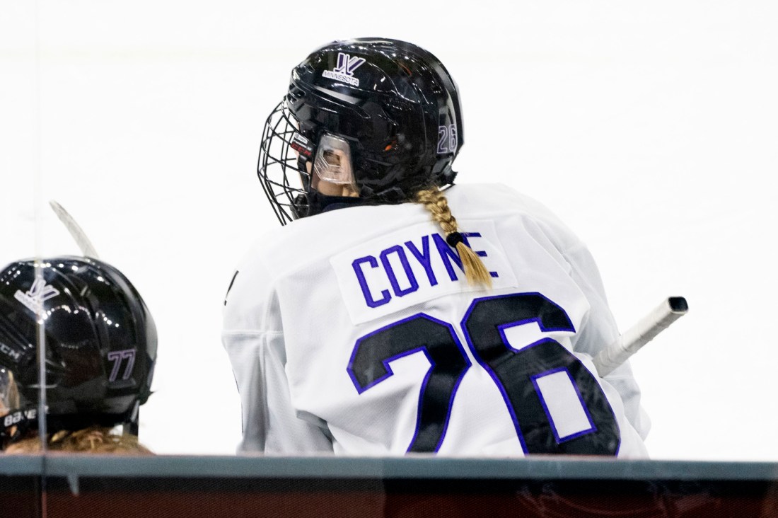 A hockey player wearing a black helmet on the ice rink.