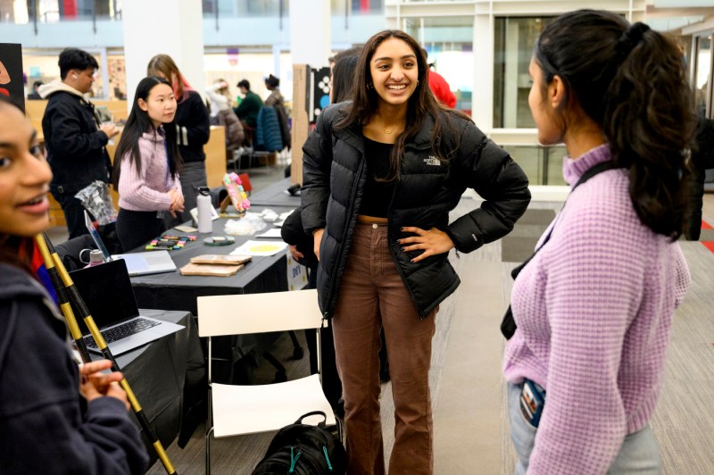 Three students standing together talking about the Winter Involvement Fair.