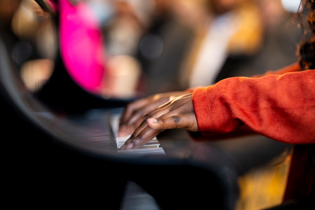 A closeup of hands playing a piano.