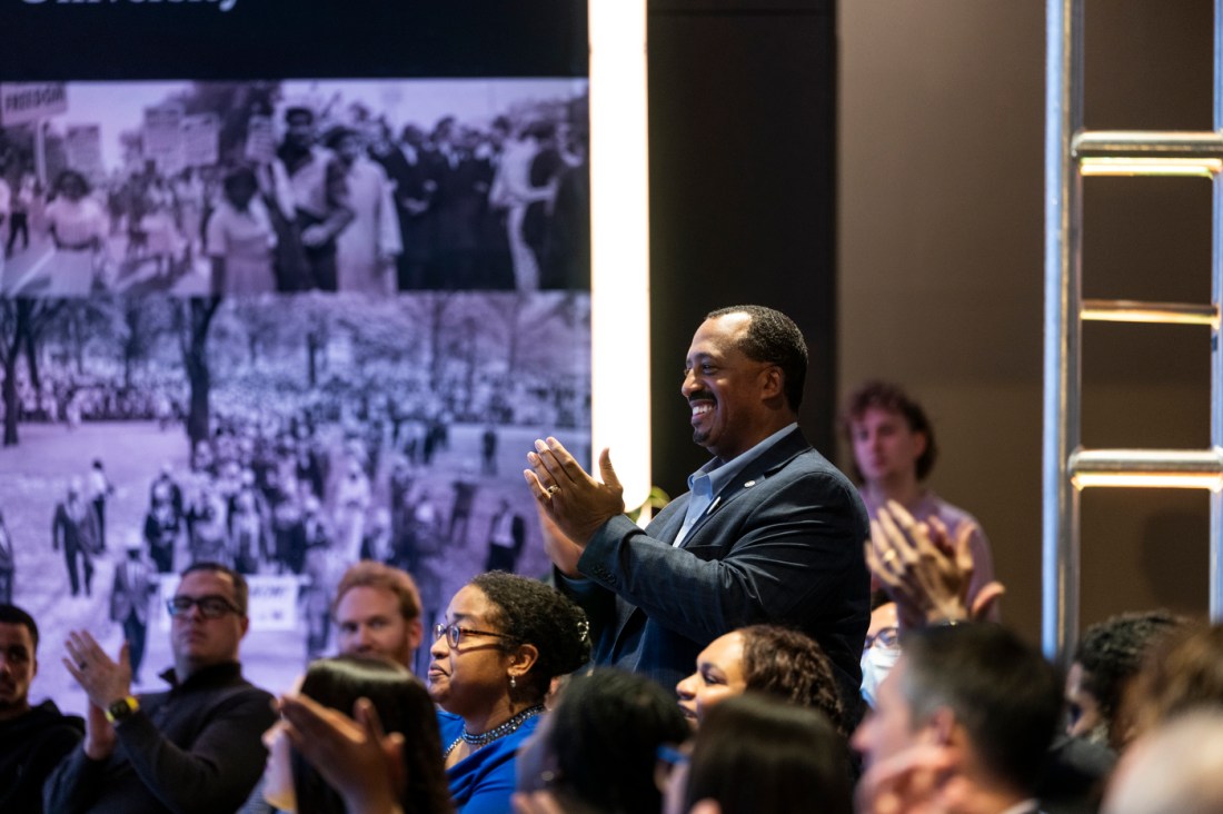 An attendee starts a standing ovation after a presentation.