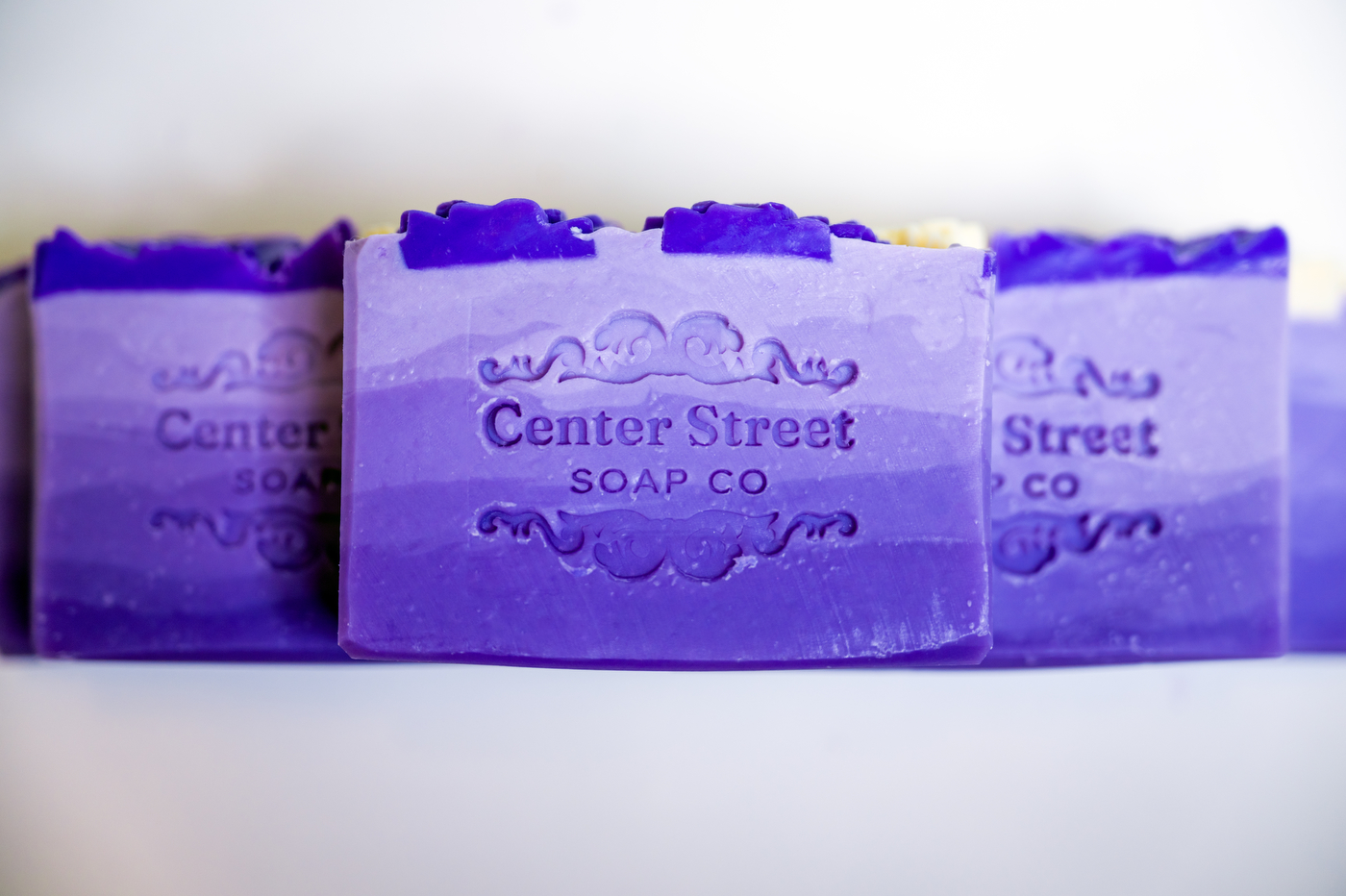 A handmade bar of purple soap embedded with the Center Street Soap Co logo.