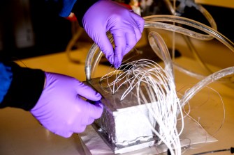 Hongwei Sun working on a battery in a lab.