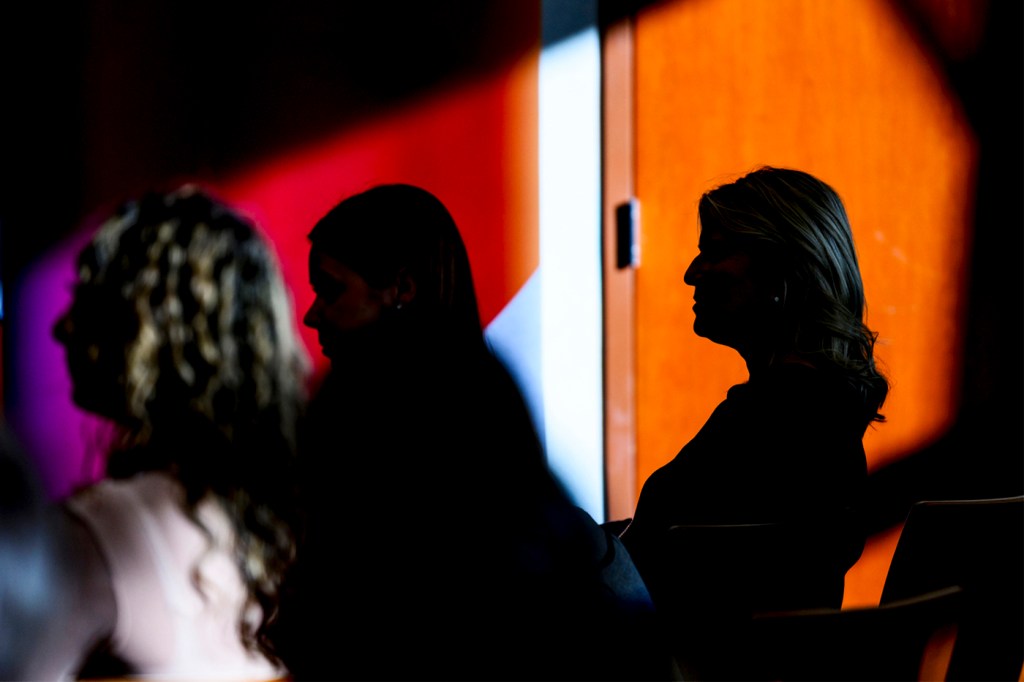 Silhouette of people sitting at an event.