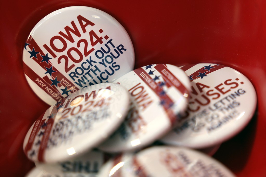 A stack of identical pins featuring a white background and red text that reads "Iowa 2024" for the state's early voting.