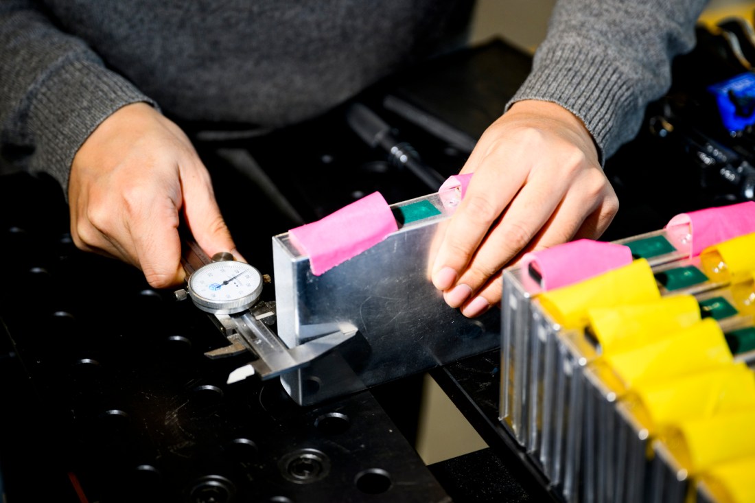 Juner Zhu working on an electrical battery.