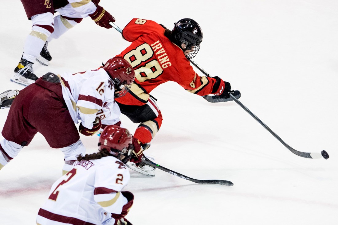 A hockey player with the title "Irving 88" on their jersey chases a puck on ice.