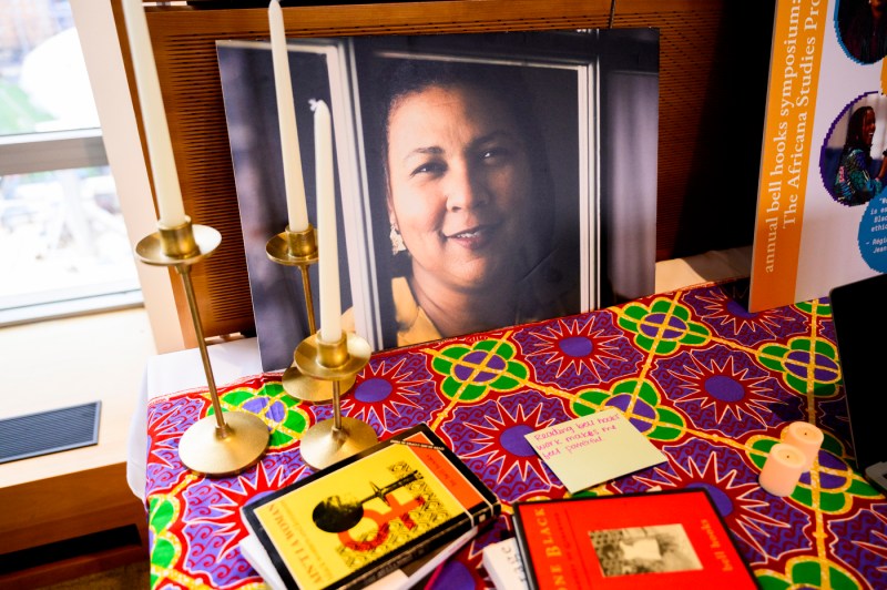 A picture of bell hooks placed on a multi-colored table surrounded by candles. 