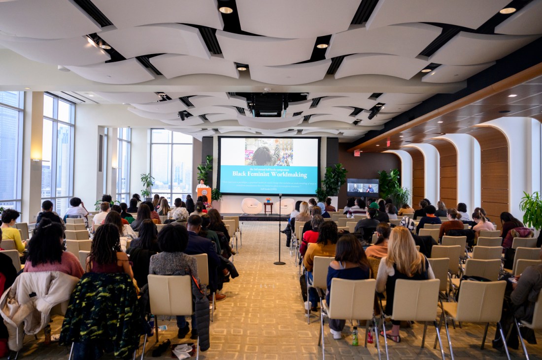 An auditorium filled with audience members looking at a PowerPoint titled “Black Feminist Worldmaking."