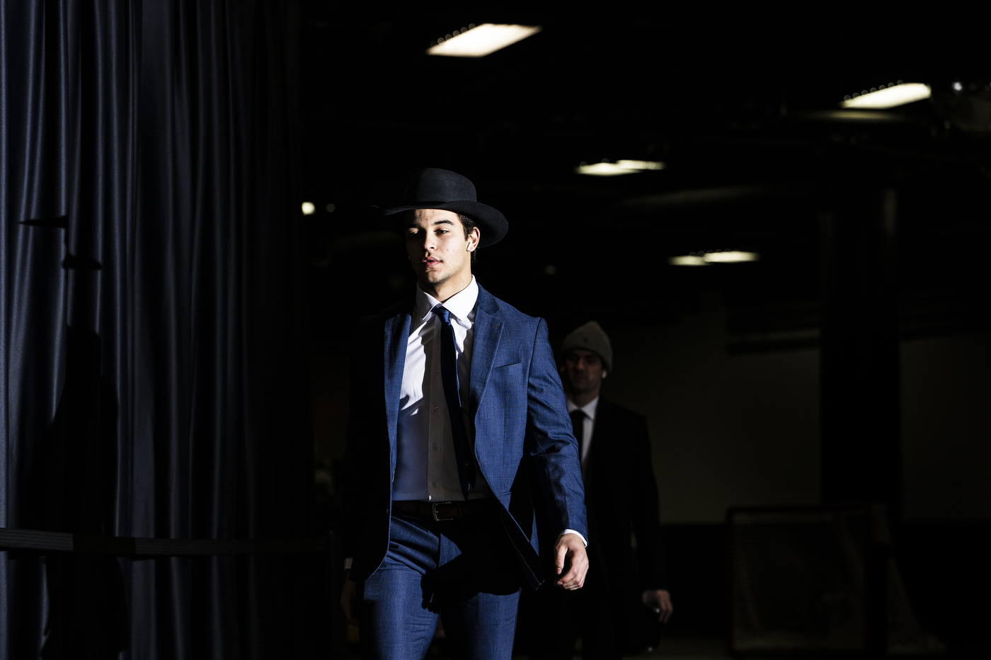 Mens hockey player wearing a suit and tie and a hat.