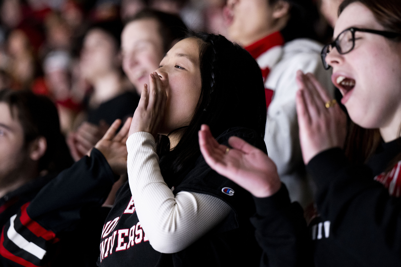 Fans in the student section cheering and clapping.