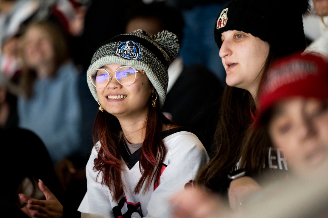 Students smiling and clapping in the crowd.