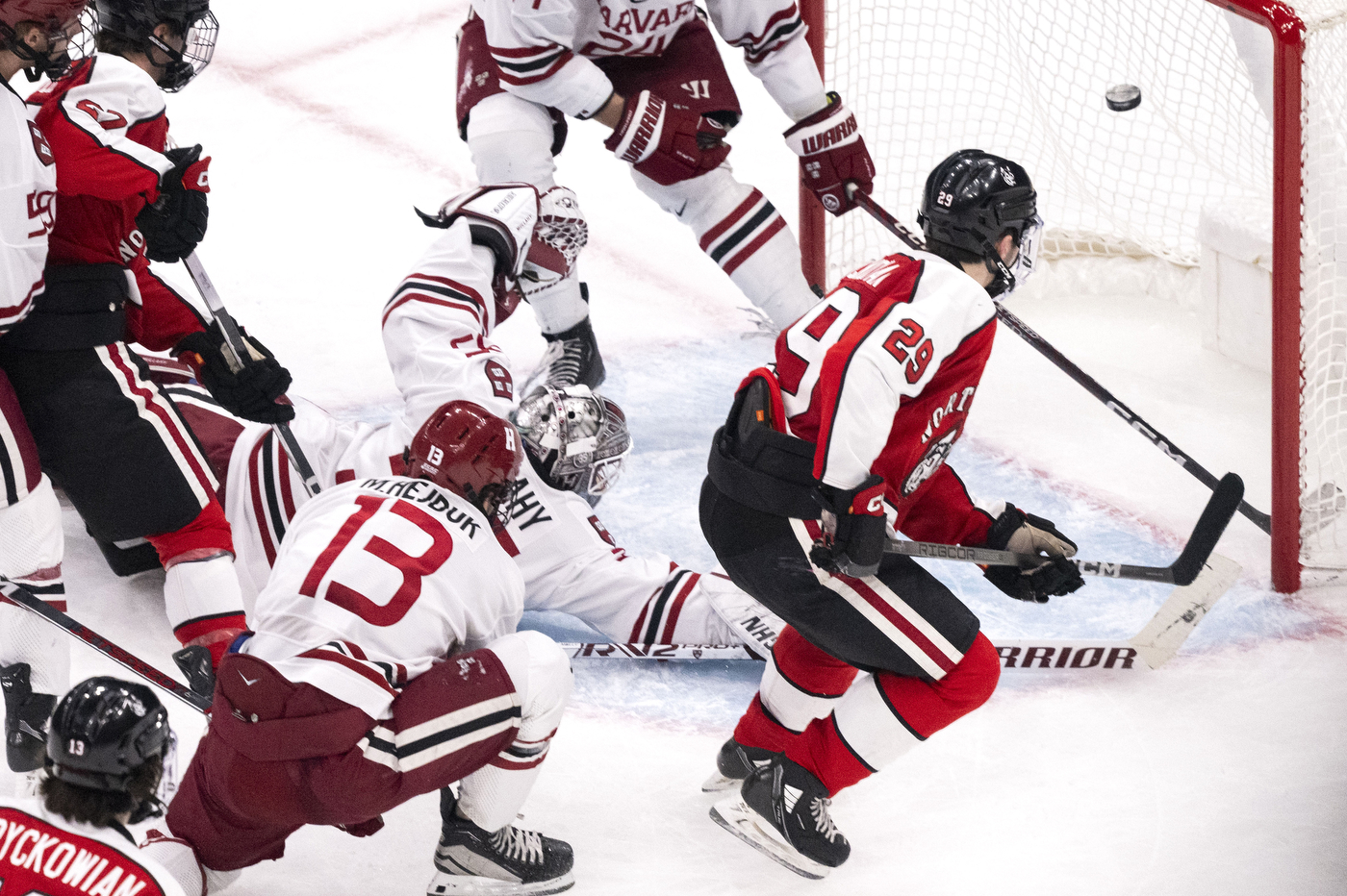 Northeastern hockey player scoring on Harvard.