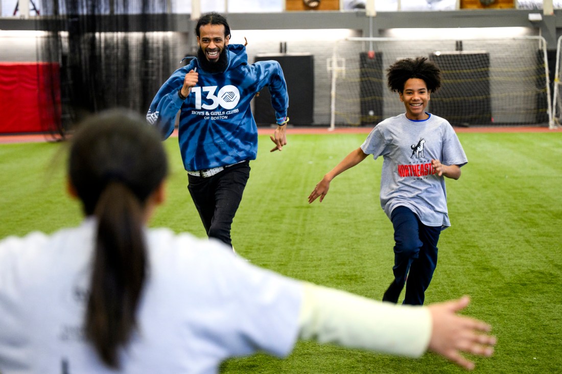 Two people racing each other down a turf field.