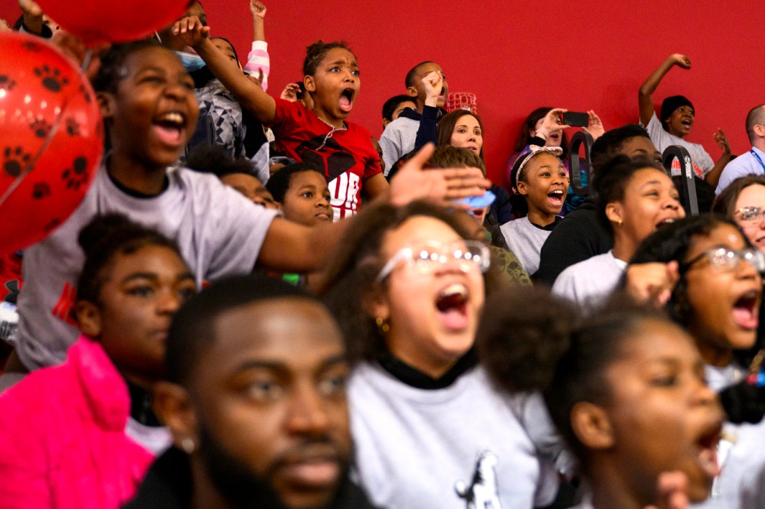 Kids cheering and yelling while sitting on the floor.