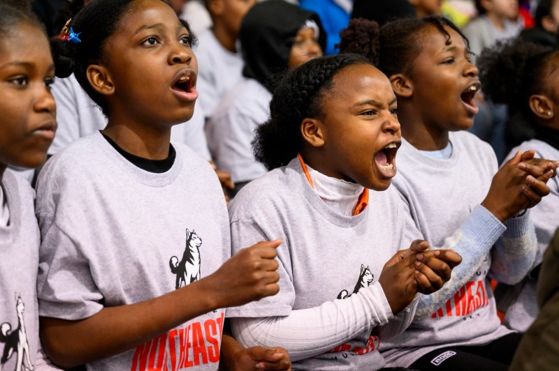 Kids wearing white t-shirts cheering.