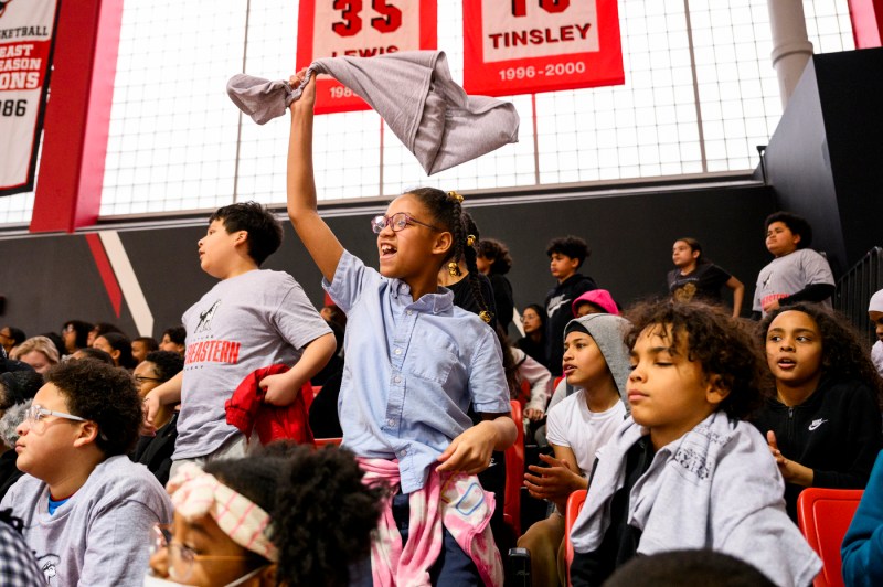 Kids cheering and waving t-shirts.