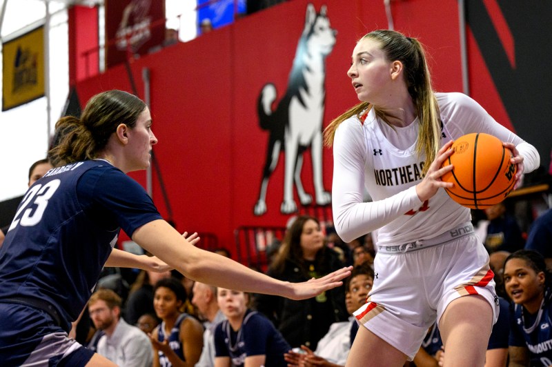 Northeastern basketball player dribbling with the ball.